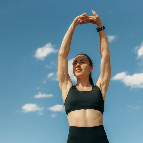 Woman stretching her arms towards the sky